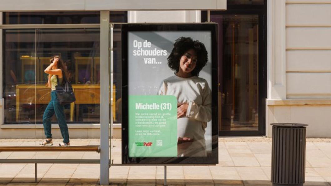 Affiche op straat voor campagne 'Op de schouders van' met zwangere vrouw